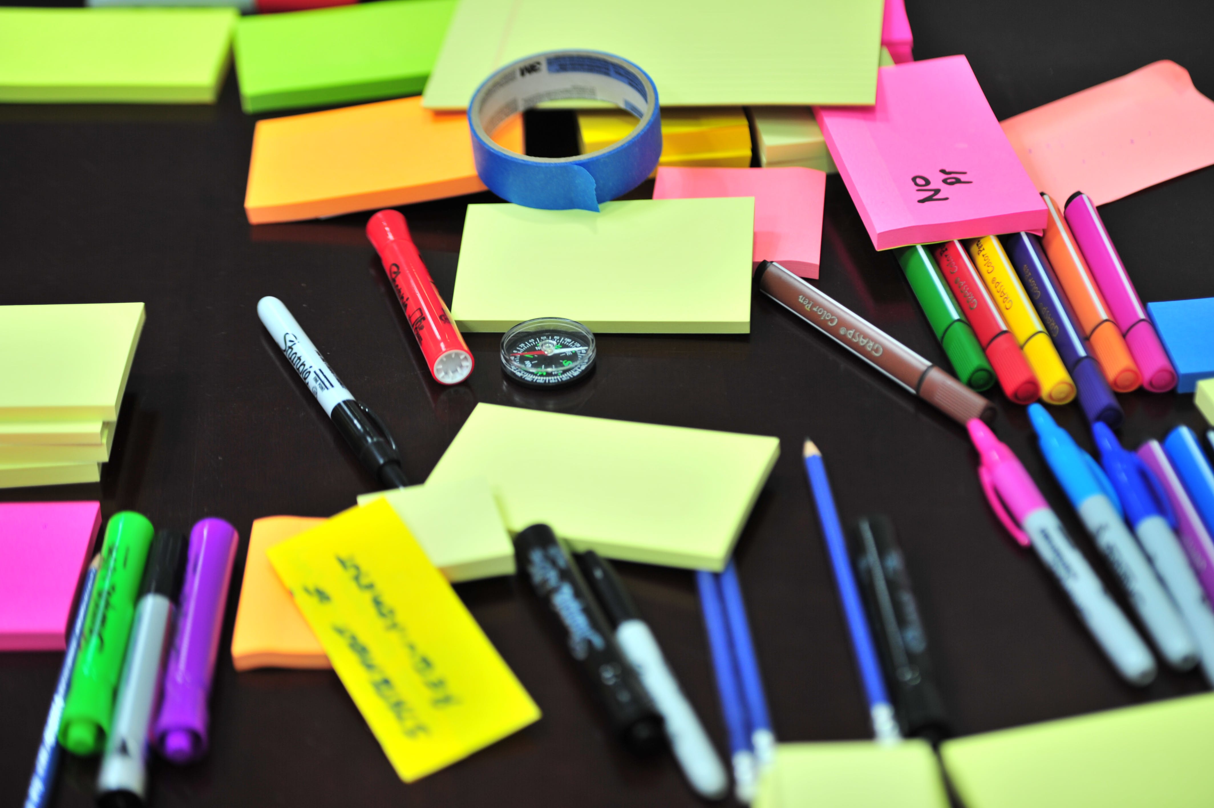 Colored sticky notes, pens, and markers used to keep organization in academic writing