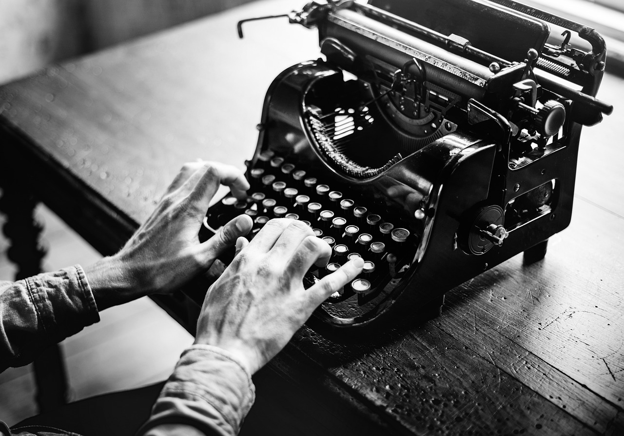Black and white image of typewriter with hands on keys; tips to write a memoir