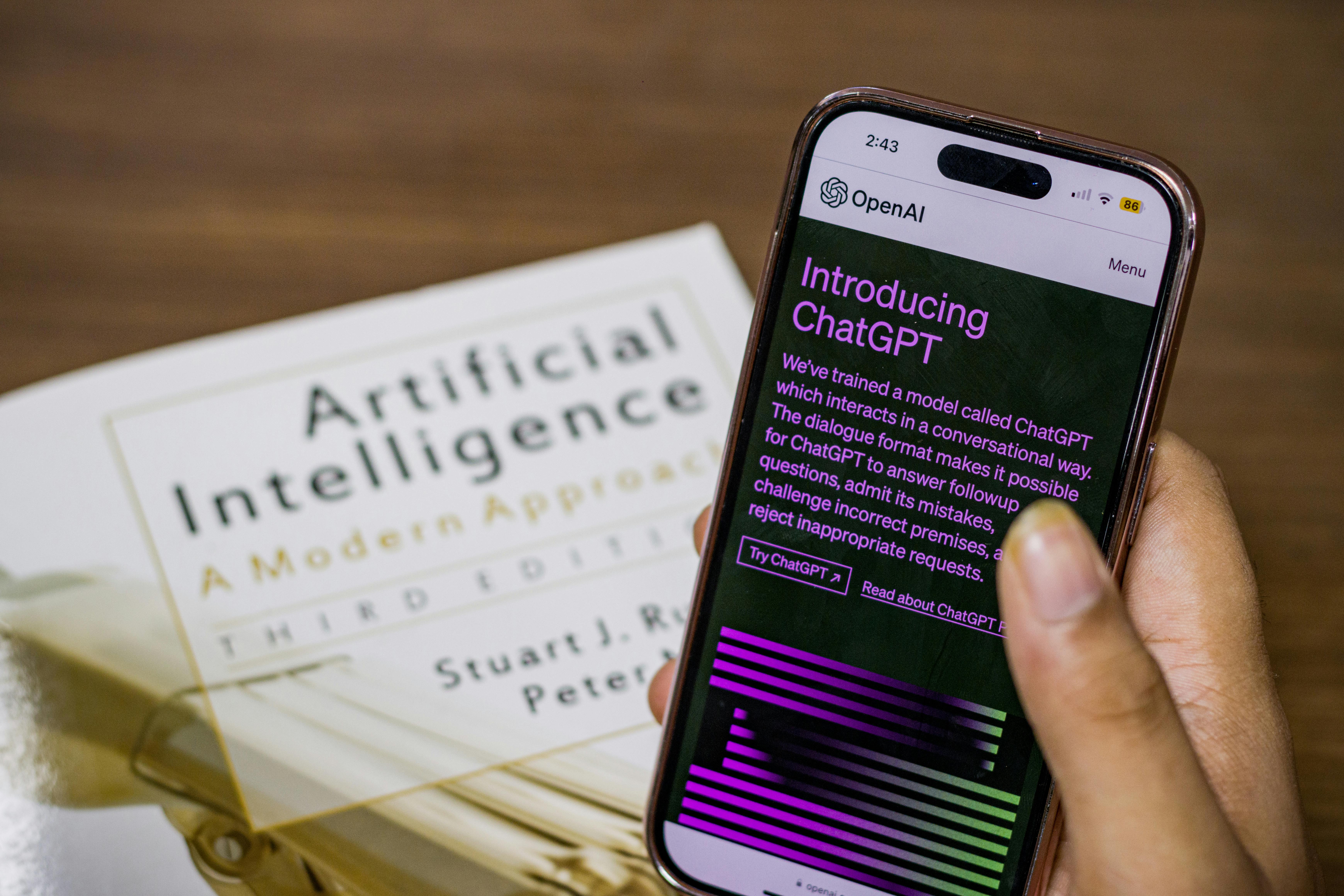 Close up image of hand holding phone, AI in book; disclaimer for a book